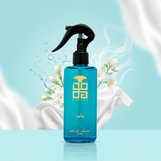 January Muzoon Perfume Lifestyle Blue spray bottle with black nozzle on a light blue background with white flowers.